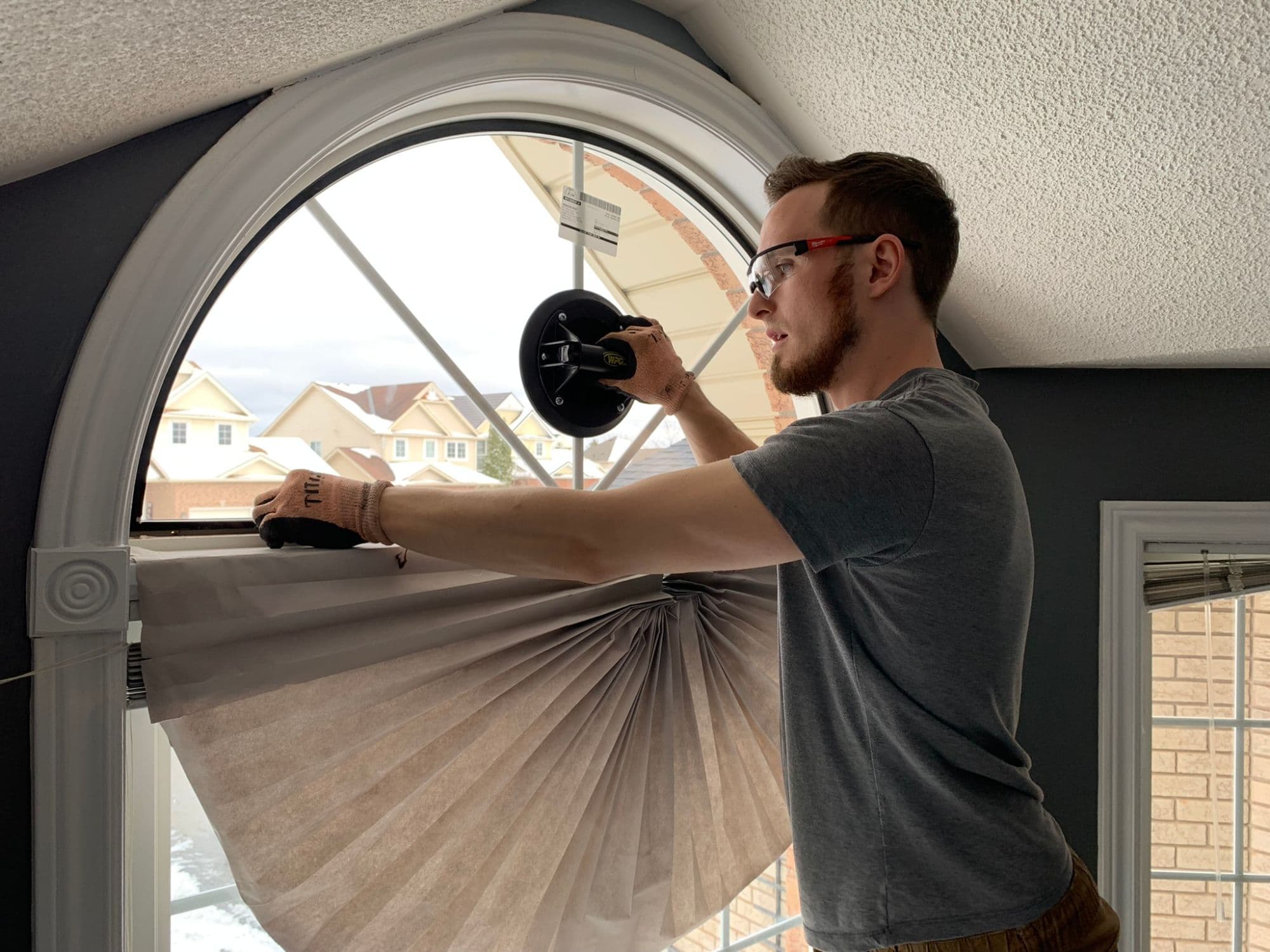 Brett from Window Whiz installing a new arched sealed unit in a home