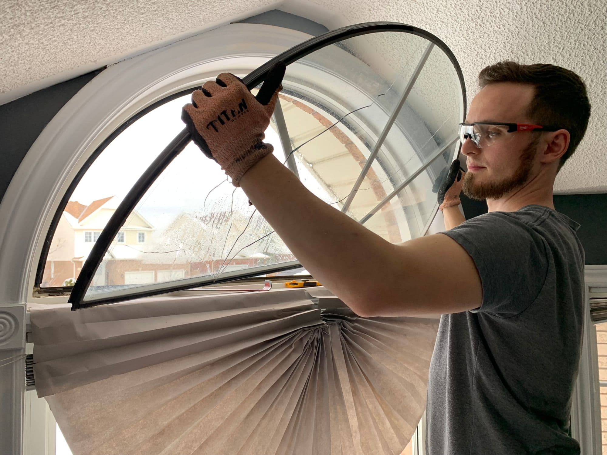 Brett from Window Whiz removing a cracked, fogged arched sealed unit from a window
